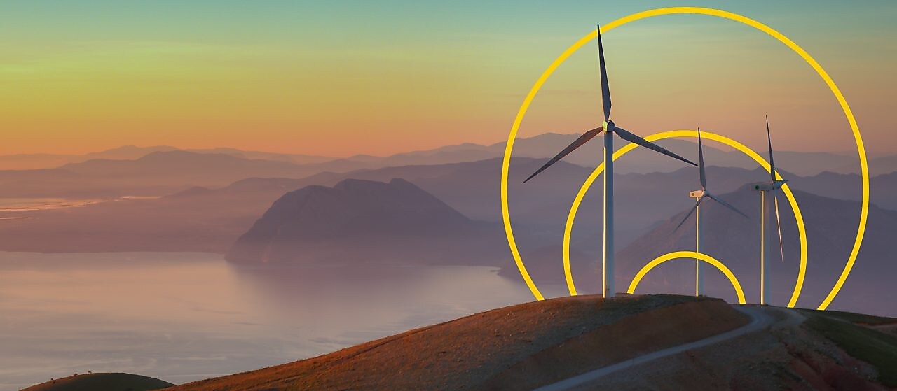 Foto de tres turbinas eólicas en una colina con un esquema del gráfico Lograr cero emisiones netas