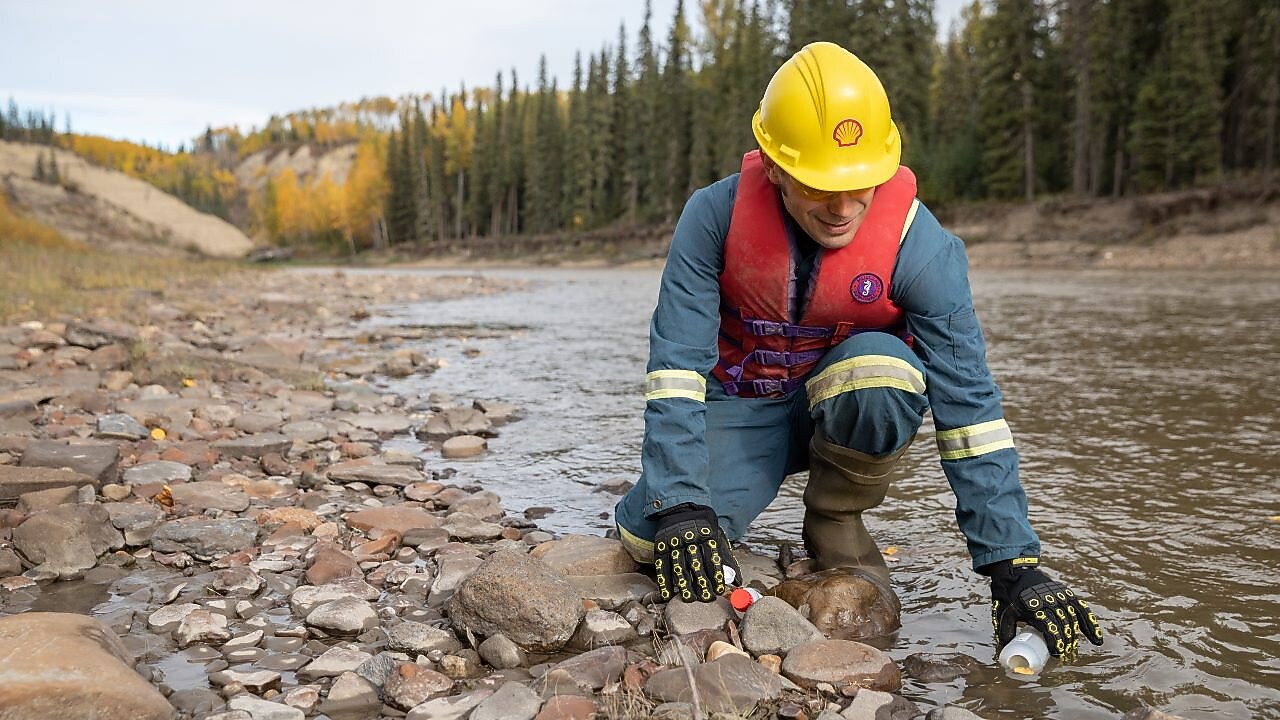 Empleado de Shell recolectando agua del río