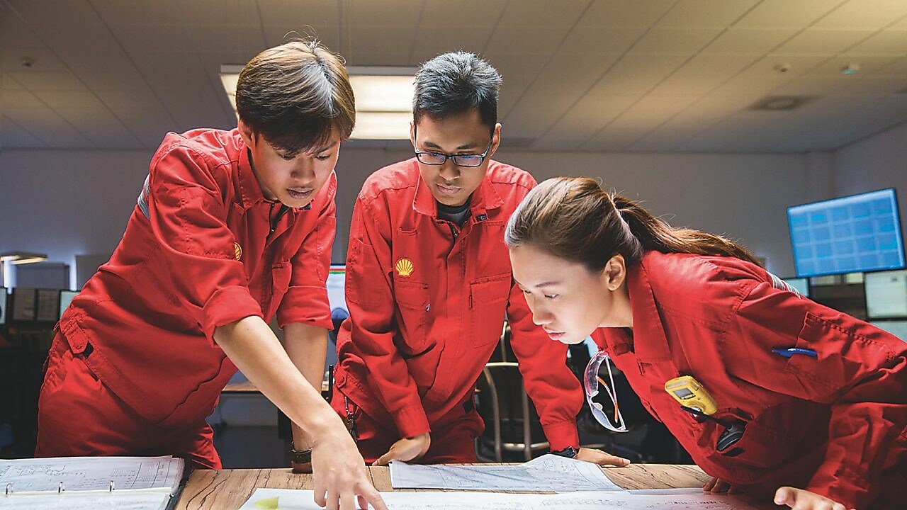 Tres empleados revisando planos