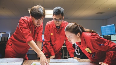 Tres empleados revisando planos