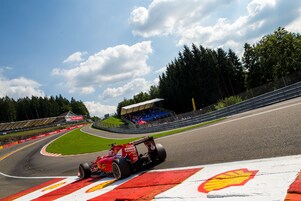 El coche rojo de Ferrari trazando una curva en un circuito de GP