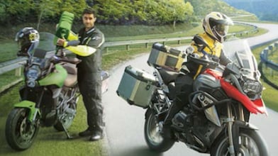 dos pilotos, uno conduciendo en la ruta; el otro, echando combustible a su motocicleta
