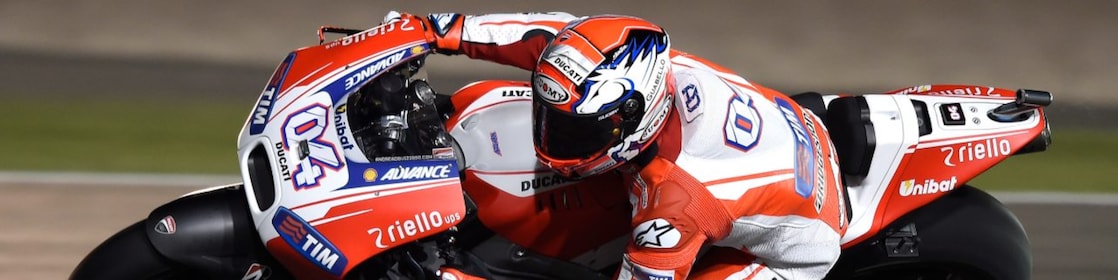 Motocicleta con piloto corriendo en una curva de una pista