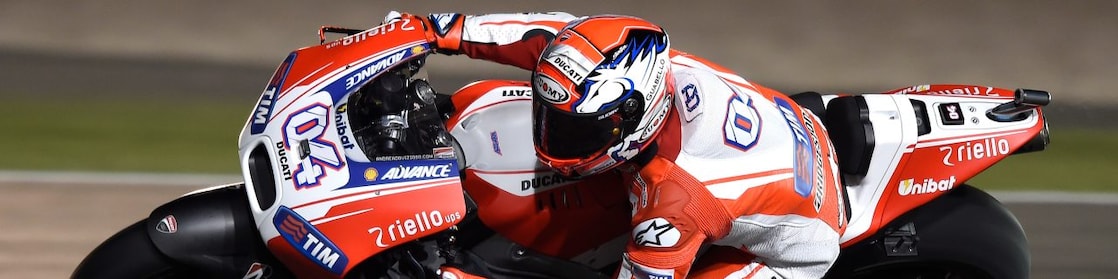 Motocicleta con piloto corriendo en una curva de una pista