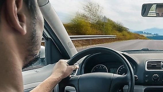 Joven conduciendo un coche en la estrada