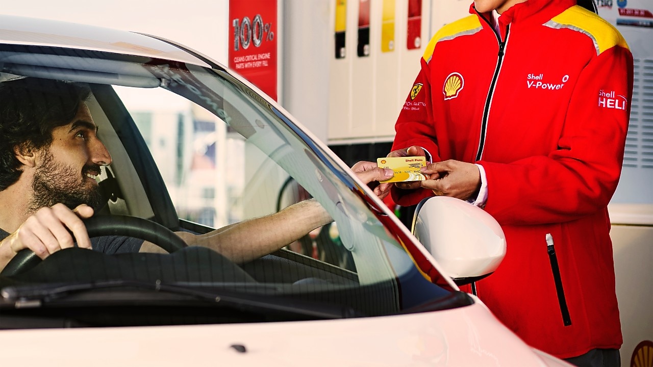 Hombre ofrece su tarjeta Shell Flota para realizar el pago de su carga de combustible